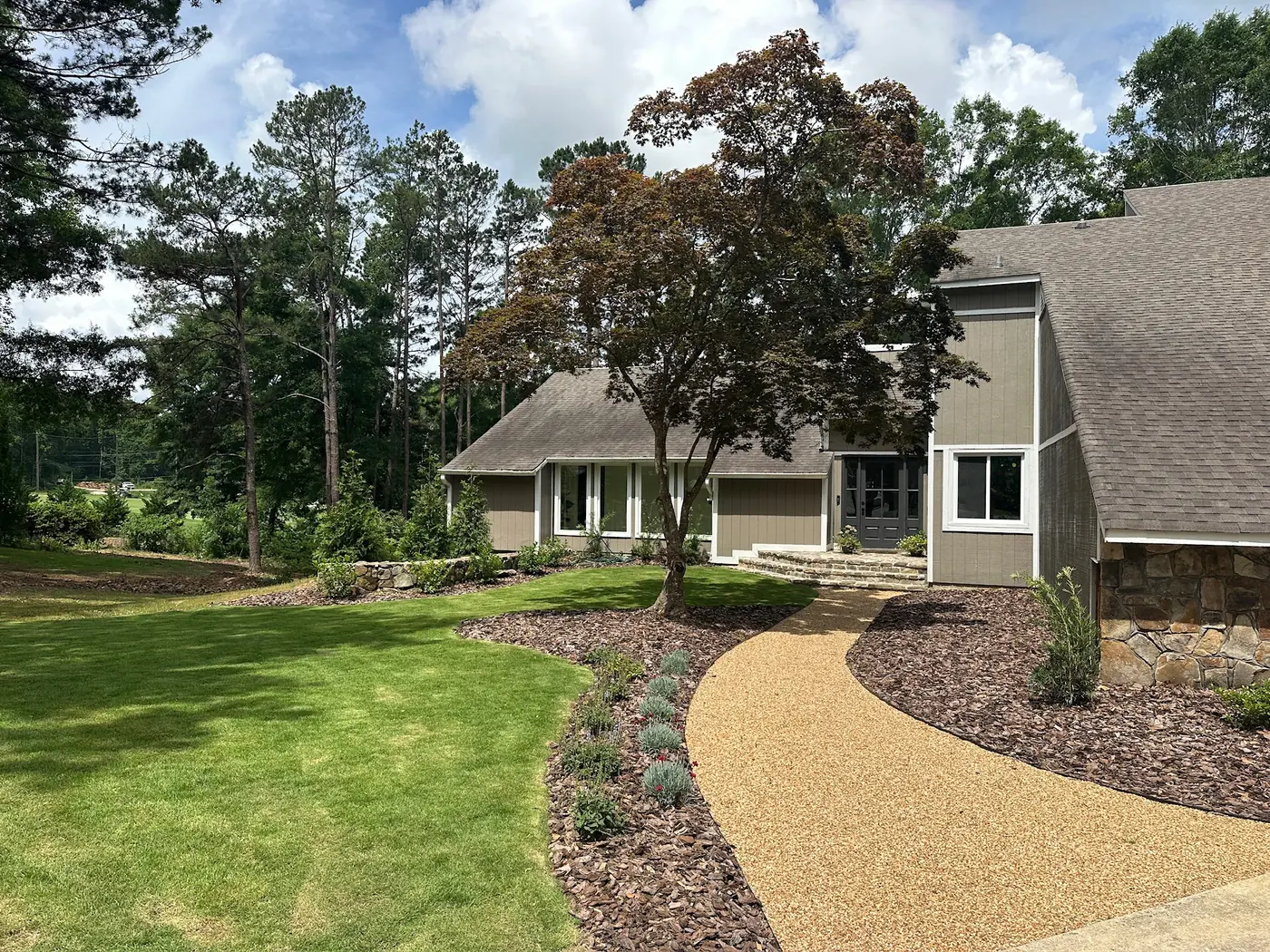 A landscaped home and lawn among mature trees in Opelika